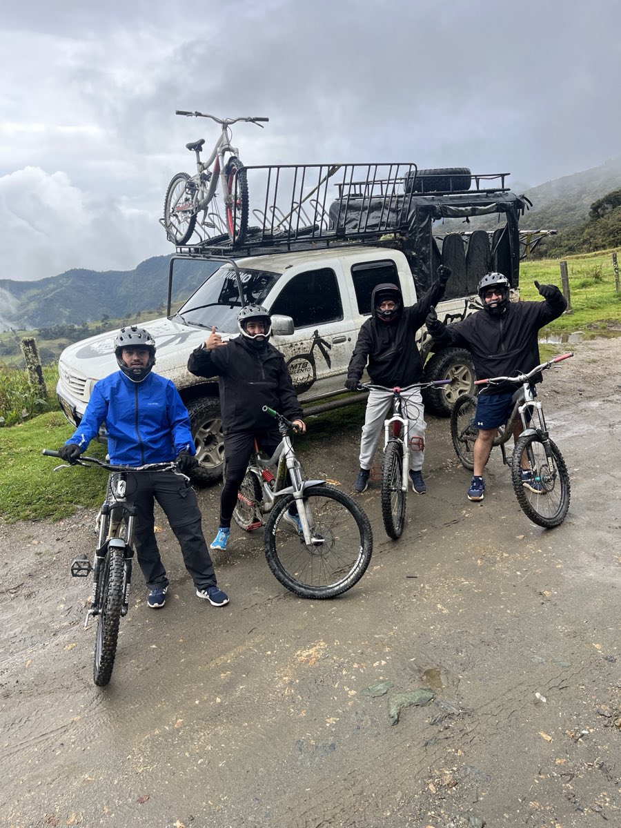 Cuatro ciclistas con sus bicis frente a la camioneta 4x4 que las subió a lo alto de la montaña